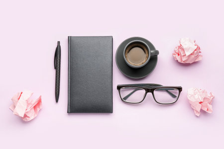 Composition with notebook, pen, eyeglasses, cup of coffee and crumpled paper balls on color backgroundの写真素材