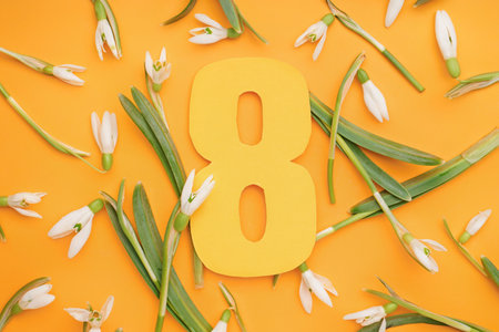 Beautiful snowdrops and number 8 on orange backgroundの写真素材
