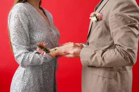 Young girl and her prom date holding hands on red backgroundの写真素材