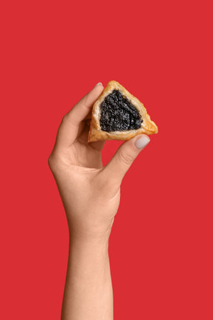 Woman with Hamantaschen cookie for Purim holiday on red backgroundの写真素材