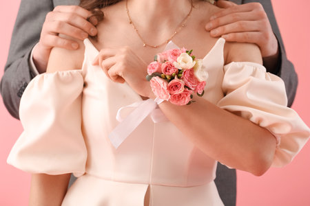 Young woman with corsage and her prom date on pink background, closeupの写真素材