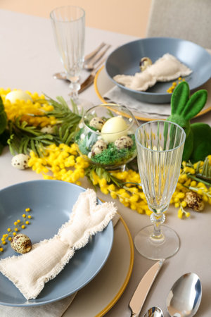 Bunnies, eggs and mimosa flowers on table served for Easter celebrationの写真素材