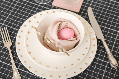 Table setting with painted egg and pussy willow branch in bowl served for Easter celebration