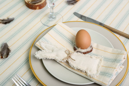 Egg and bunny in plate served for Easter celebration, closeup