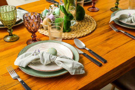 Table setting with painted egg, napkin and gypsophila flowers served for Easter celebrationの写真素材