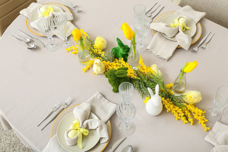 Festive table setting with painted eggs and flowers served for Easter celebrationの写真素材