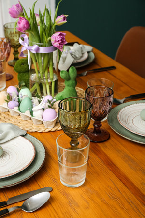 Festive table setting with painted eggs and flowers served for Easter celebration