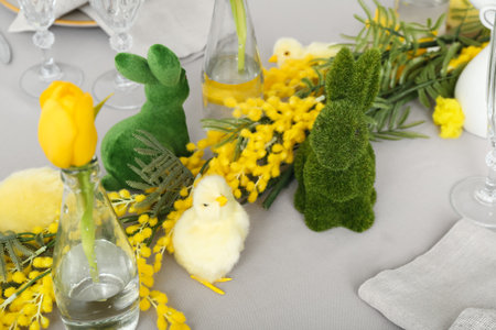 Festive table setting with baby chickens and bunnies for Easter celebrationの写真素材