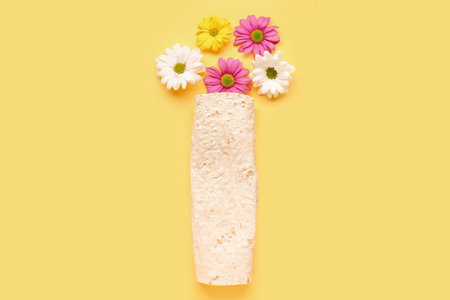 Creative composition with lavash and beautiful flowers on yellow backgroundの写真素材