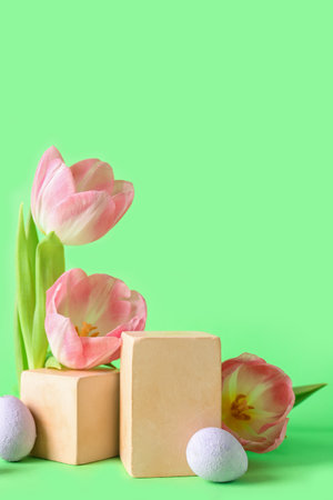 Composition with podiums, tulip flowers and Easter eggs on green backgroundの写真素材