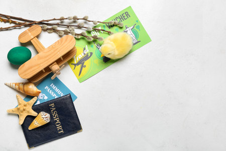 Travel voucher with toy airplane, seashells, chicken, Easter egg and willow branches on white backgroundの写真素材