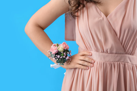 Young woman in prom dress with corsage on blue background, closeupの写真素材