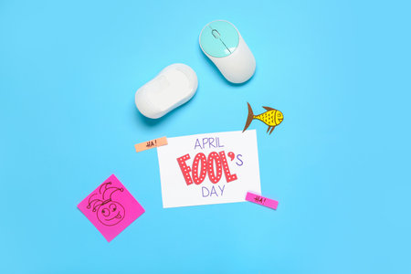 Computer mouses, paper decor and card with text APRIL FOOL'S DAY on color backgroundの写真素材