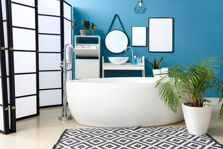 Interior of bathroom with sink, bathtub and blank framesの写真素材