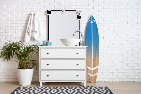 Interior of bathroom with sink, drawers and surfboardの写真素材