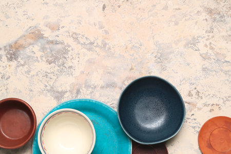 Composition with clean ceramic plates and bowls on grunge backgroundの写真素材