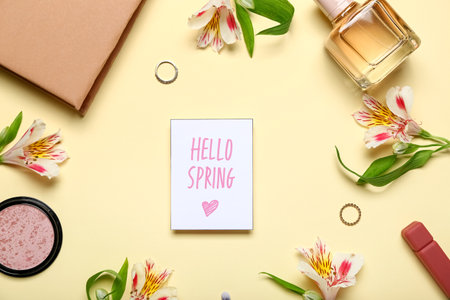 Card with text HELLO SPRING, cosmetics, accessories and alstroemeria flowers on color backgroundの写真素材