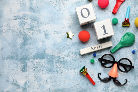 Date 1 APRIL with party decor for Fools' Day celebration on blue grunge backgroundの写真素材
