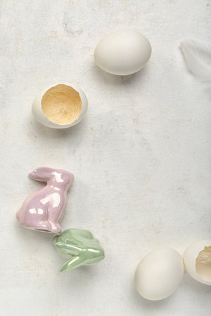 Frame made of Easter eggs and bunnies on gray background