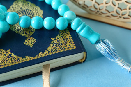 Koran with prayer beads for Ramadan on blue background, closeupの写真素材
