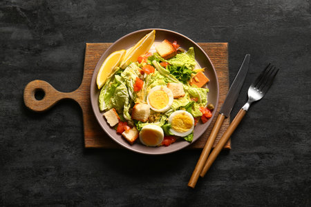 Plate of delicious salad with boiled eggs and salmon on black grunge backgroundの写真素材