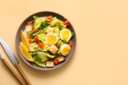 Plate of delicious salad with boiled eggs and salmon on beige backgroundの写真素材