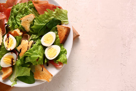 Plate of delicious salad with boiled eggs and jamon on white grunge backgroundの写真素材