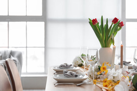 Beautiful table setting for International Women's Day celebration with different flowers in interior of light roomの写真素材