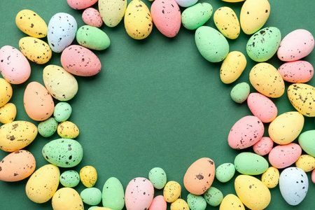 Frame made of colorful Easter eggs on green backgroundの写真素材