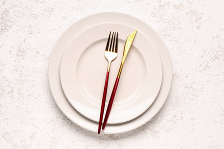 Plates with fork and knife on white grunge backgroundの写真素材