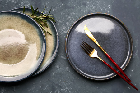 Plate with fork and knife on gray grunge background