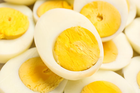 Halves of delicious boiled eggs as background, closeupの写真素材