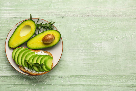 Plate with delicious avocado toast on green wooden backgroundの写真素材