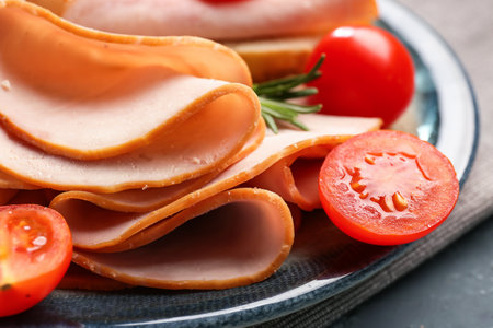 Plate with slices of tasty ham and tomatoes, closeupの写真素材