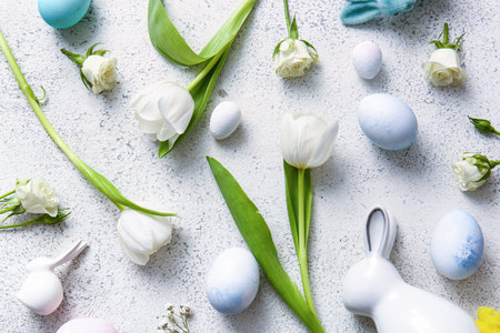 Composition with beautiful flowers, Easter eggs and bunnies on light backgroundの写真素材
