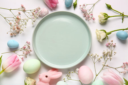 Composition with empty plate, Easter eggs and flowers on white backgroundの写真素材