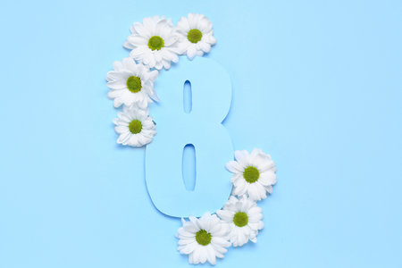 Composition with paper figure 8 and chamomile flowers on color background. Women's Day celebrationの写真素材