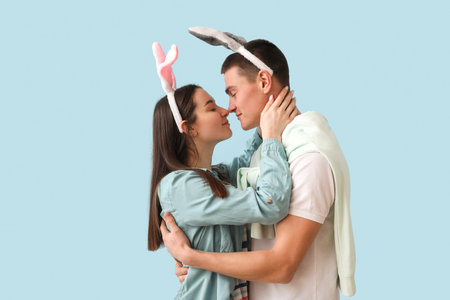 Happy young couple in bunny ears hugging on blue background. easter celebrationの写真素材