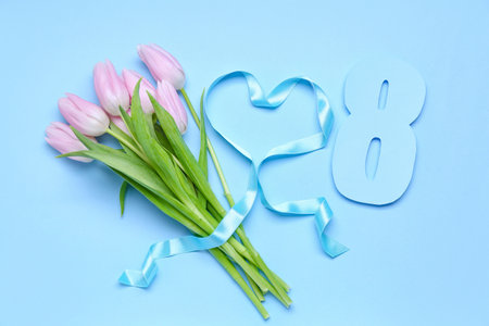 Bouquet of beautiful tulip flowers, paper figure 8 and heart made of ribbon on color background. Women's Day celebrationの写真素材