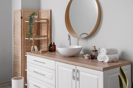 Interior of light bathroom with counters, sink and mirrorの写真素材