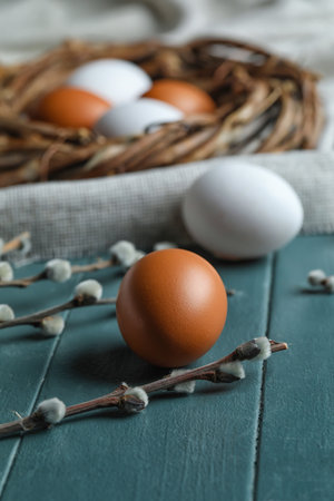 Easter eggs and willow branches on wooden background, closeup