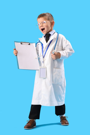 Happy little doctor with clipboard on blue backgroundの写真素材