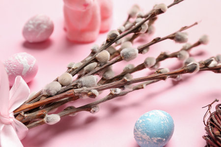 Willow branches and Easter eggs on pink background, closeup