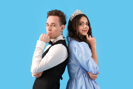 Thoughtful couple dressed for prom on blue backgroundの写真素材