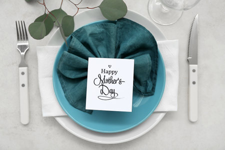 Stylish table setting with eucalyptus branch for Mother's Day celebration on light background