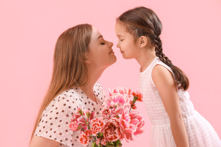 Cute little girl and her mother with flowers on pink background, closeupの写真素材