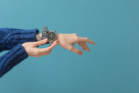 Woman with stylish wrist watch on blue backgroundの写真素材