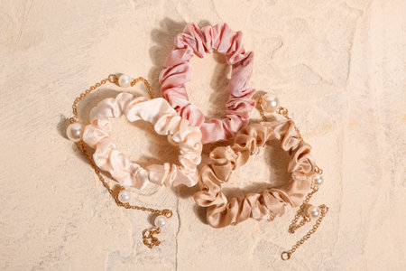 Silk scrunchies with necklace on light backgroundの写真素材