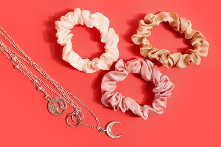 Stylish female accessories and scrunchies on red backgroundの写真素材
