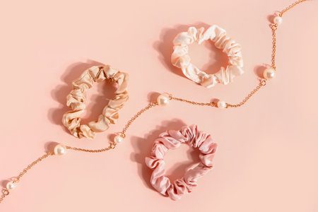 Silk scrunchies and necklace on pink backgroundの写真素材